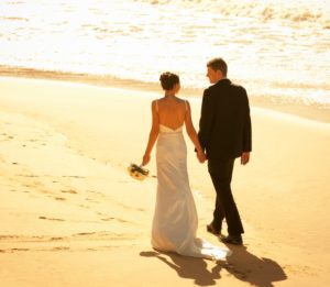 Couple walking on the beach after their marriage